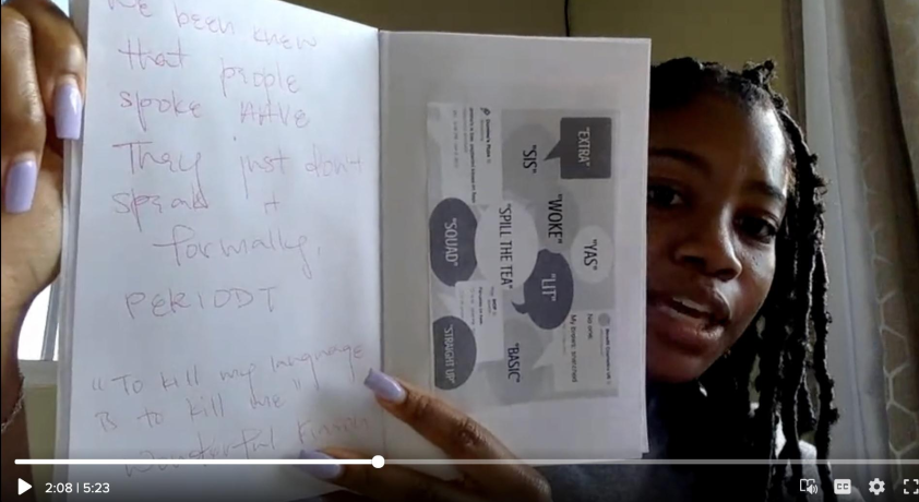 This photo shows Zoey holding open her zine. On the right zine page, Zoey has created a collage of tweets and quotes in AAVE. On the left zine page, she has written, 'We been knew that people spoke AAVE. They just don't speak it formally. Period. To kill why language is to kill me. Wonderful Faison.'
